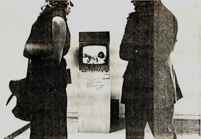 Photograph of spectators watching the screen outside the room for A Change of Plan. (by Tim Burns).